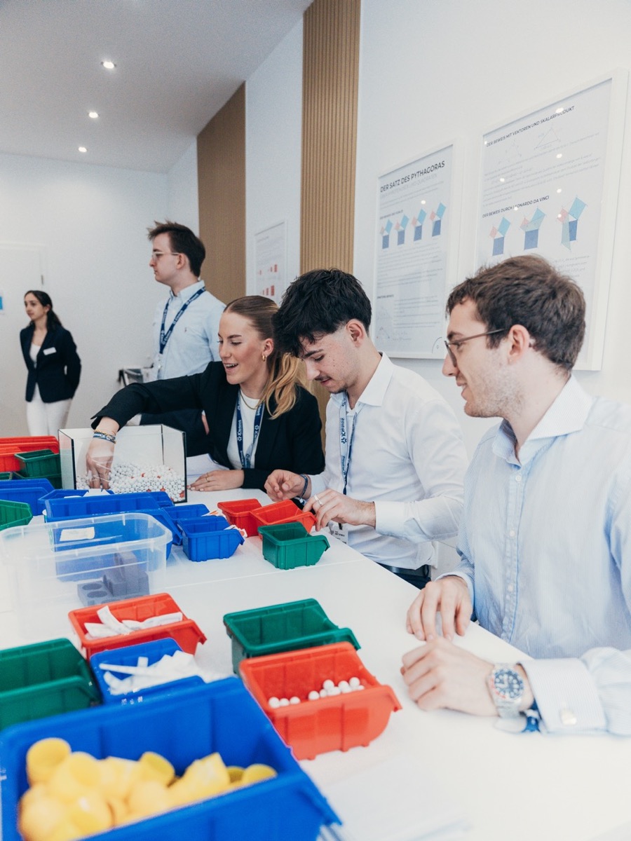 Teilnehmende sortieren bunte Materialboxen für eine Workshop-Übung